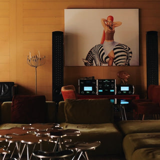 Living room with a large painting of a woman on a zebra, surrounded by furniture and decor.